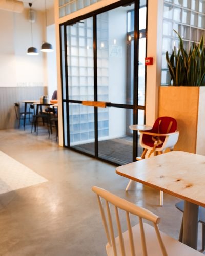 Empty table and chairs in cafeteria with display-case near by