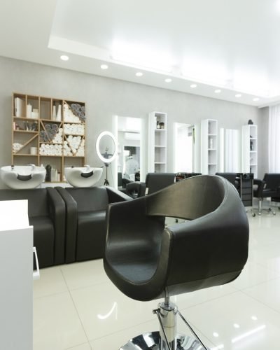 Barber chair and backlit mirror in bright Interior, free space