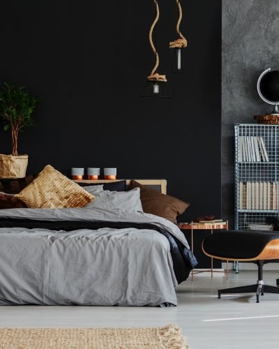 Eco style grey and black bedroom with comfortable bed and armchair